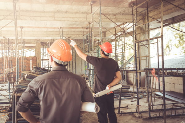 Condições e Meio Ambiente de Trabalho na Indústria da Construção: profissionais usando equipamentos de proteção conversando.
