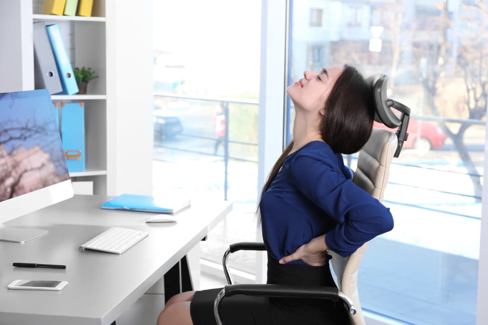 Ergonomia no trabalho: mulher massageando o pulso.